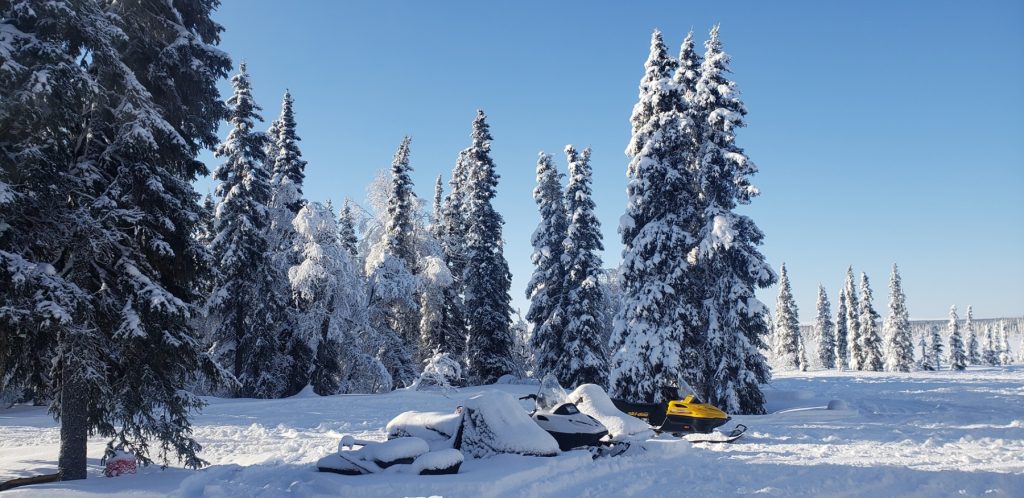 Snowmobiles parked by hunting camp in Alaska